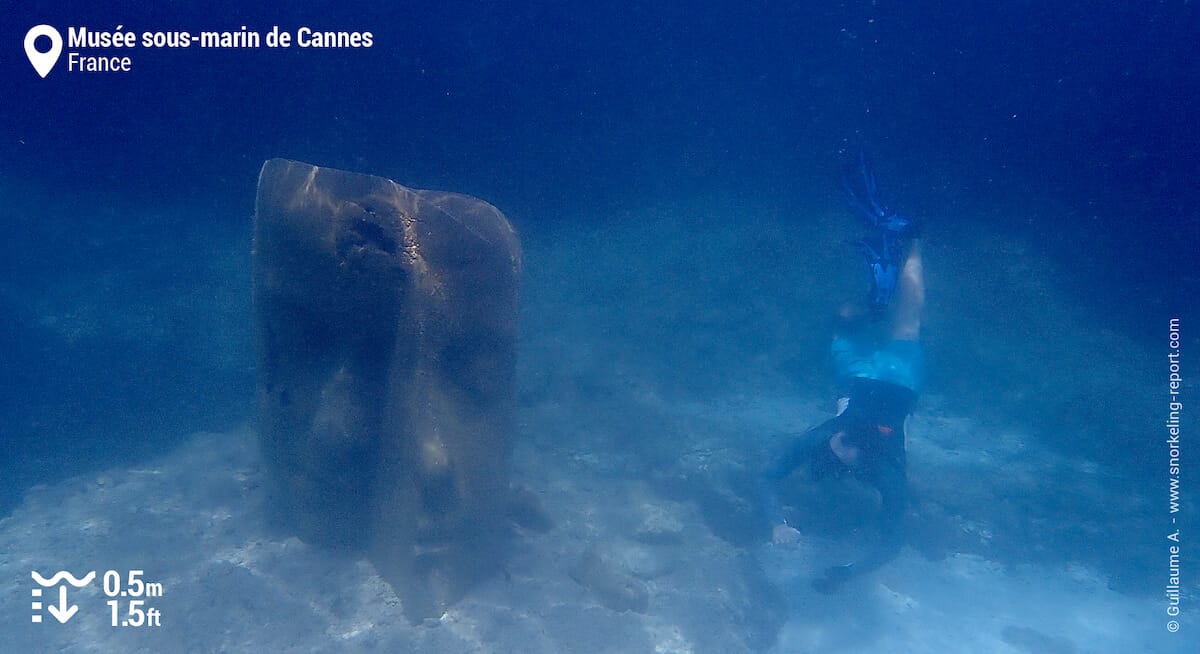 Un plongeur à côté d'une sculpture de Jason Decaires Taylor à Cannes